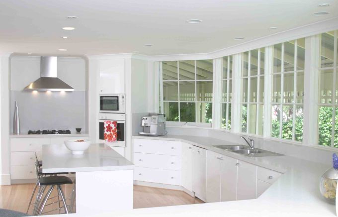 Ample-Kitchen-Windows-Supporting-Bright-White-Kitchen-Interior-with-Wooden-Floor.jpeg